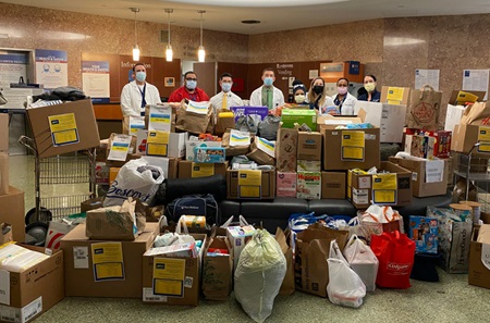 PPMC’s Gene Gofman, Jim Ballinghoff, and members of the Diversity and Inclusion Committee and Community Outreach Council stand with bags and boxes of humanitarian supplies bound for Ukraine.
